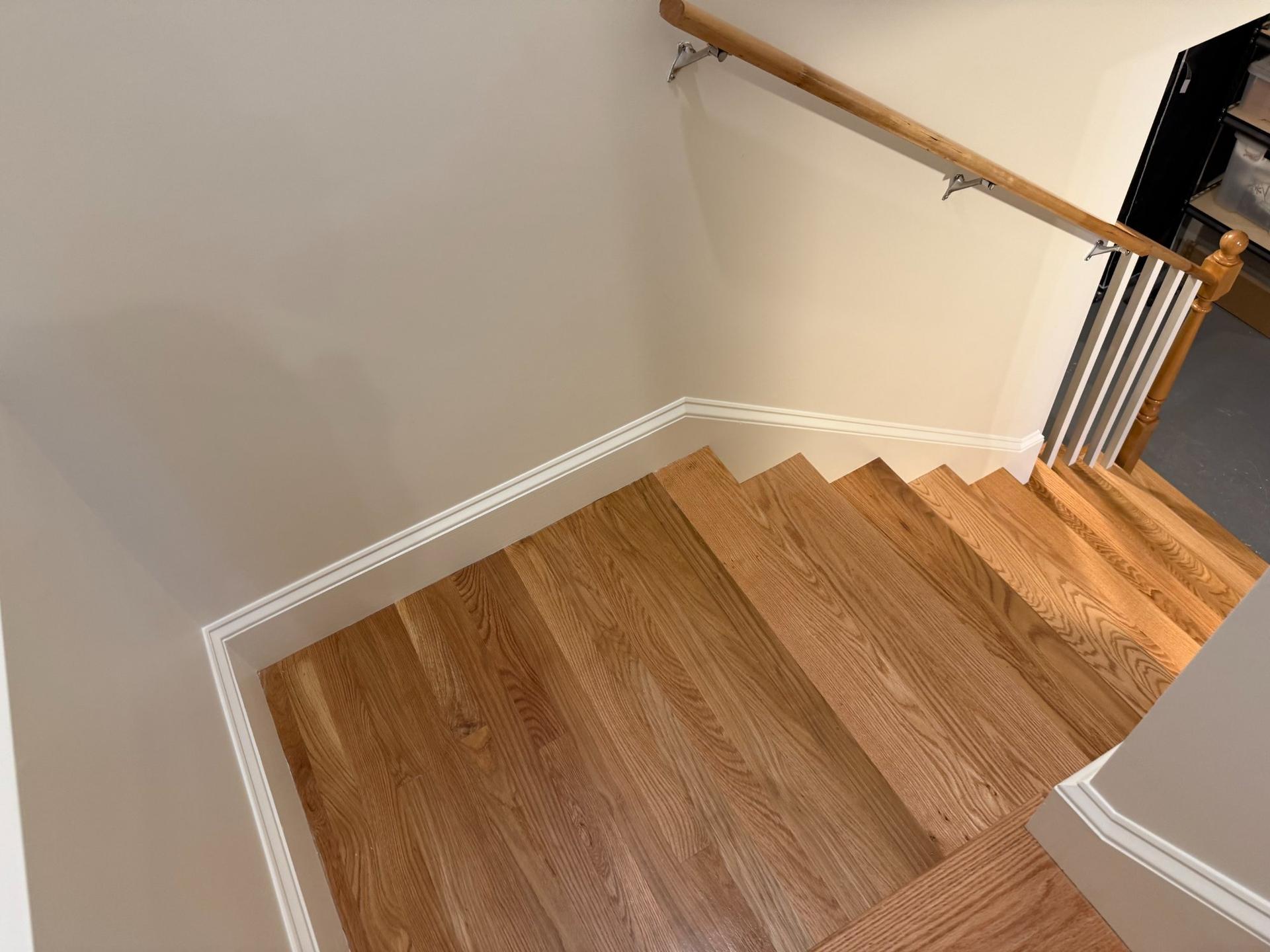 New hardwood oak staircase to basement with painted white risers and balustrade