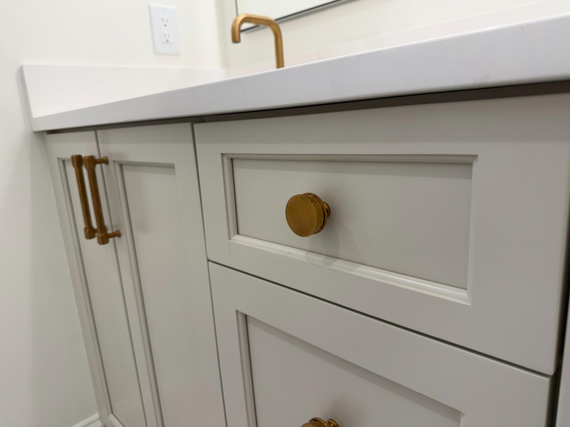 Shaker cabinet hardware detail with brushed gold knob and bar pull