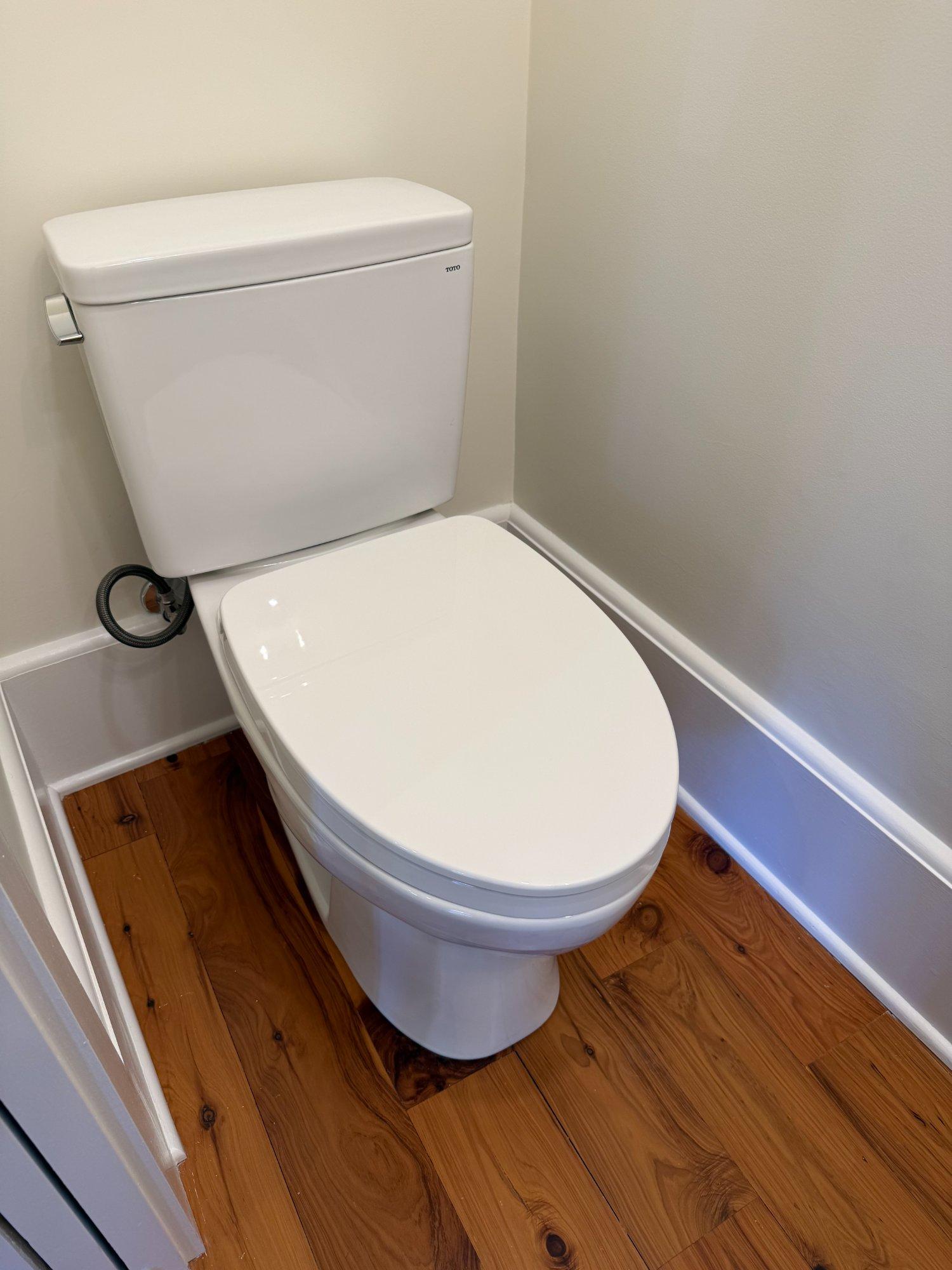 New half bath TOTO toilet with hardwood floors and painted trim