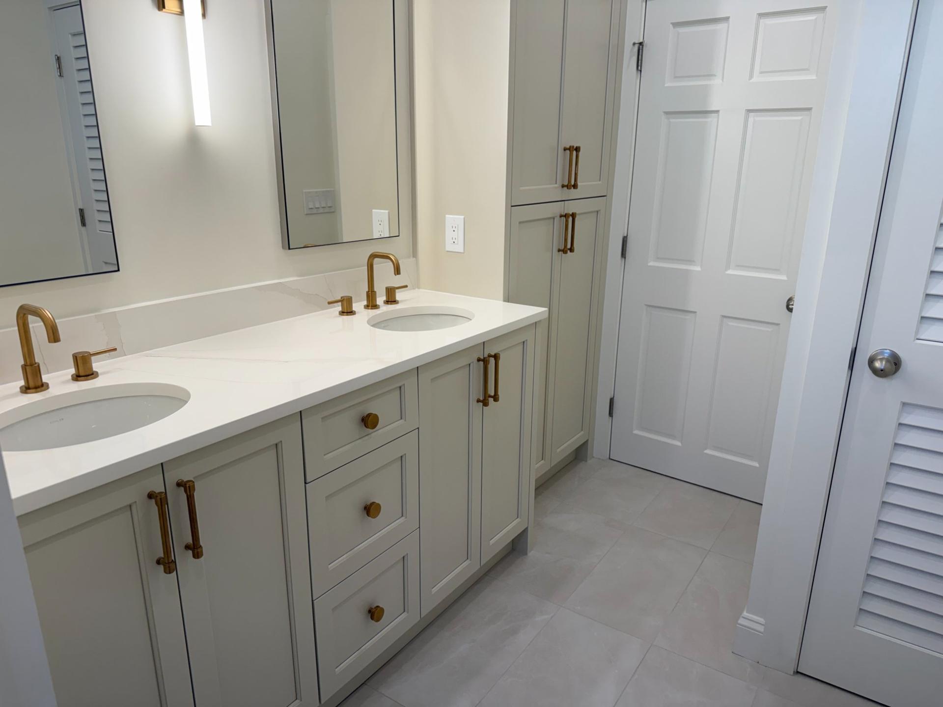 Full master bathroom with double vanity, linen tower and porcelain tile floor