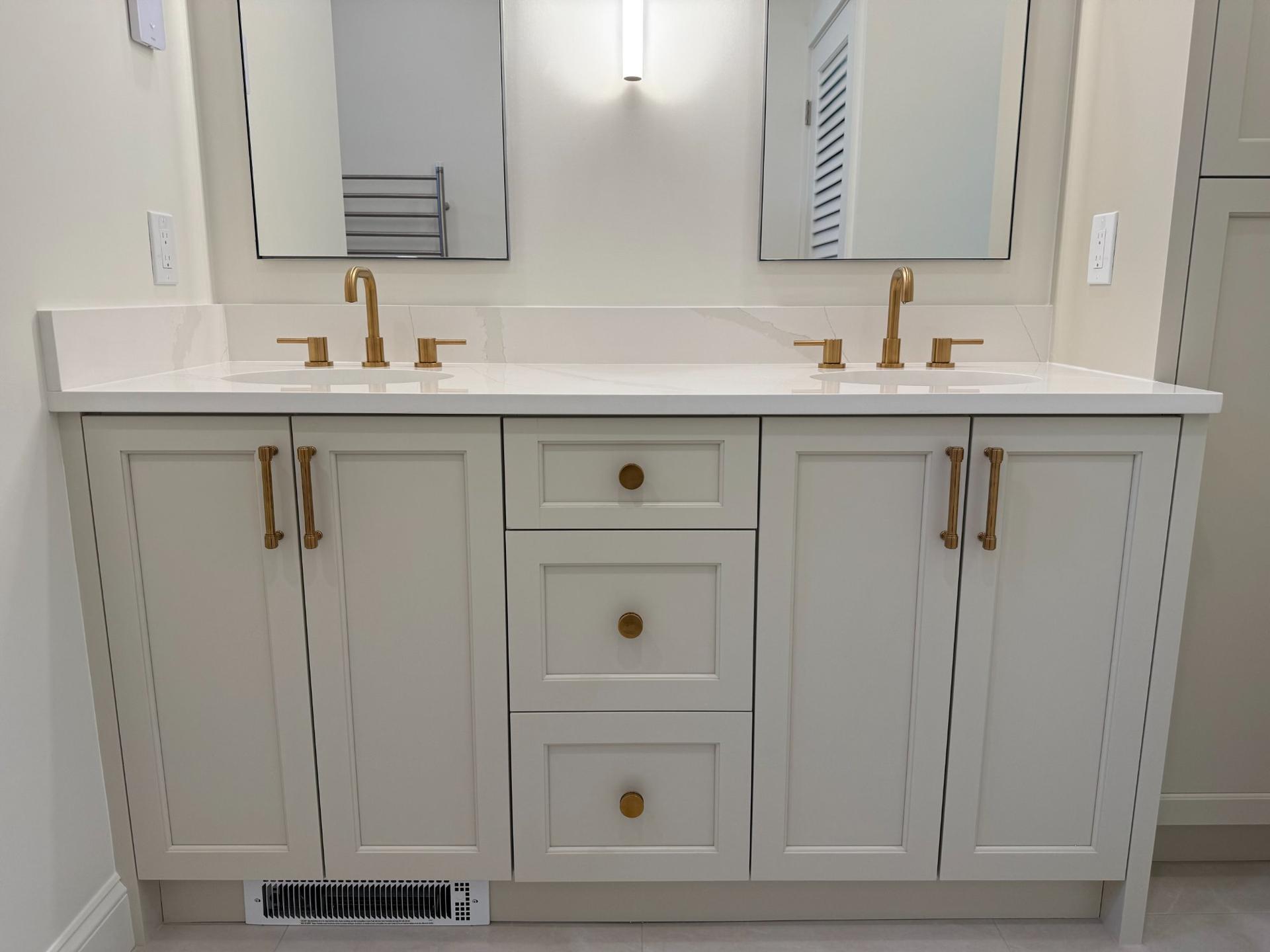 Double vanity front view with arched mirrors and brushed gold sconce lighting