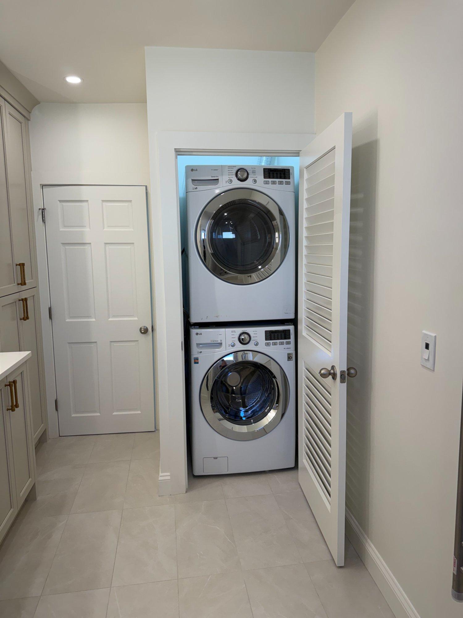 Stacked LG front-load washer and dryer in dedicated laundry closet